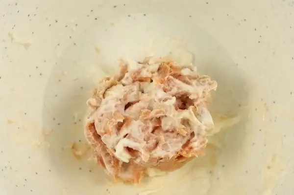Eine Portion Leberwurst liegt mittig in einer hellen Schüssel, umgeben von einer glatten, neutralen Oberfläche.
