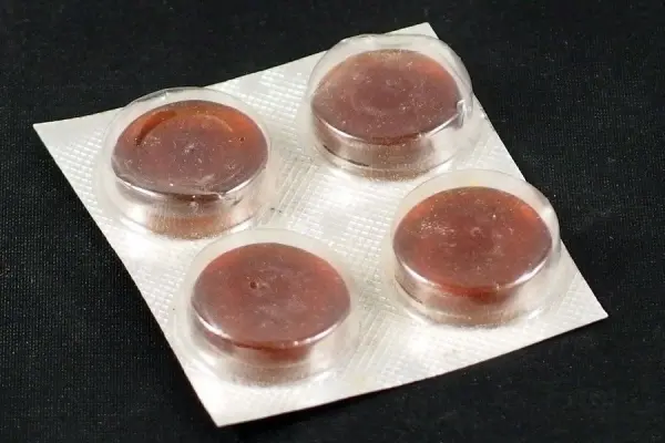 Runde Lutschpastillen liegen auf einer Blisterverpackung und könnten helfen, Würgereiz beim Zahnarzt zu verringern.
