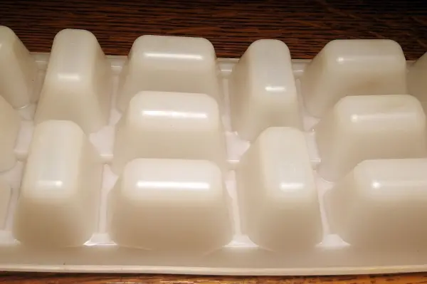 Ein Eiswürfelbehälter gefüllt mit Salatöl steht in einer Küche, bereit zum Einfrieren für bessere Eiswürfel.