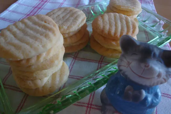 Butterkekse liegen ordentlich auf einem grünen Teller, während eine kleine Figur daneben steht, die den Tisch dekoriert.