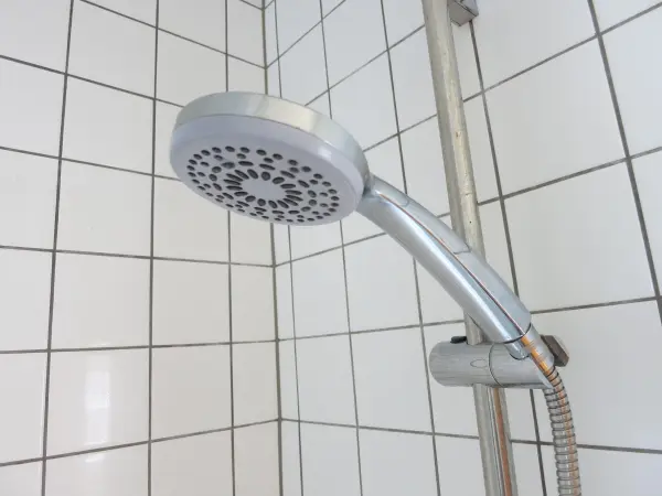 Ein Duschkopf ist an einer Fliese montiert, während Wasser für effektives Duschen zirkuliert, um Wasser zu sparen.