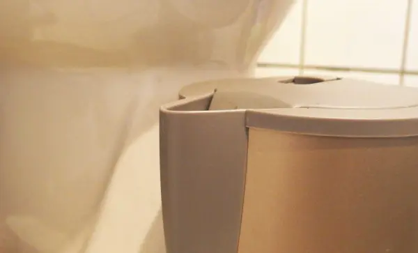 Ein Wasserkocher steht neben einer Toilette, beide werden gleichzeitig entkalkt, sichtbar in einem Badezimmer.