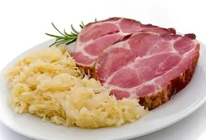 Kassler liegt saftig auf einem Teller, begleitet von würzigem Sauerkraut, bereit zum Genießen.