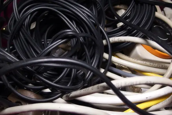 Verwirrte Kabel liegen ineinander verwoben in einem Behälter, was ein chaotisches Bild der Ordnung zeigt.