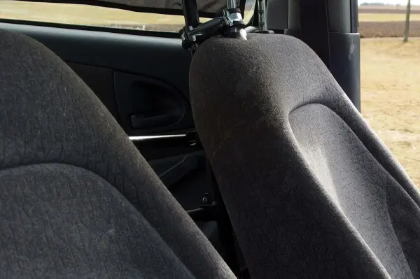 Zwei Autositze in einem Fahrzeug sind sichtbar, wobei der rechte Sitz verschmutzt wirkt und gereinigt werden sollte.