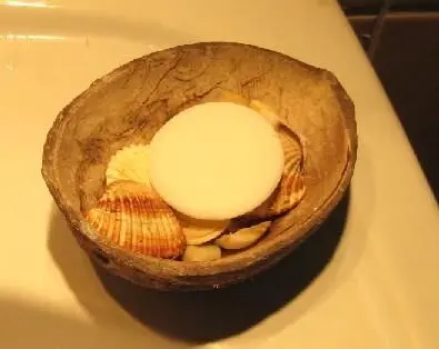 Seife liegt auf Muscheln in einer Schale, verhindert Schmierrückstände, platziert auf einem Waschbeckenrand.