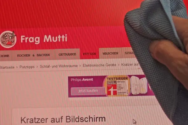 Ein Hand wischte mit einem Tuch über einen Computerbildschirm, auf dem "Kratzer auf Bildschirm" steht.