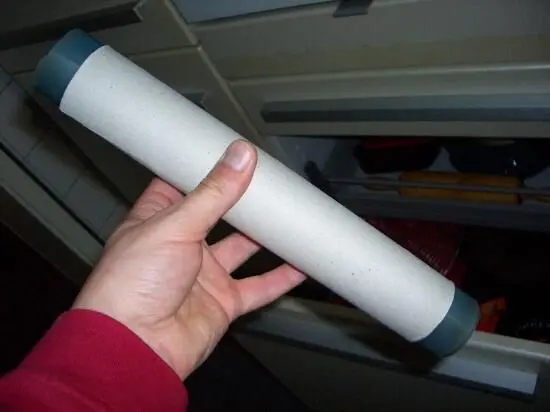 Ein Hand hält eine Silikon-Backfolie, die sicher in einer Küchenschublade verstaut wird, um Platz zu sparen.