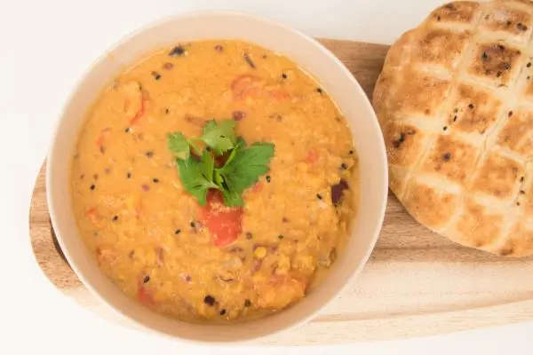 Indisches Linsengericht (Daal): cremiges Linsen-Daal mit Tomaten und Gew&uuml;rzen, dazu warmes Fladenbrot &ndash; so wie im Artikel beschrieben.