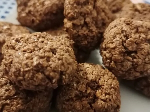 Schwarzbrötchen liegen verstreut auf einem Teller, knusprig und schokoladig, bereit für die festliche Weihnachtssaison.