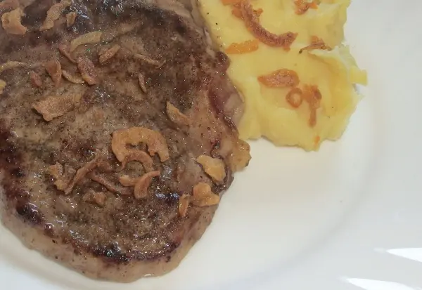 Ein Teller mit einem Stück Fleisch und Beilage aus Kartoffelpüree steht bereit, um schnell abgekühlt zu werden.