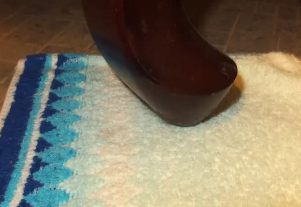 Ein Möbelstück steht auf einem Waschlappen, um Kratzer auf dem Boden zu vermeiden. Die Szene zeigt eine einfache Haushaltslösung.