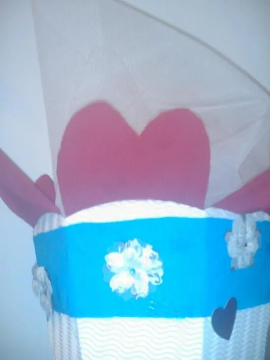 Eine farbenfrohe Schultüte für Eheanfänger, dekoriert mit Herzen und Blumen, steht dekorativ an der Wand.