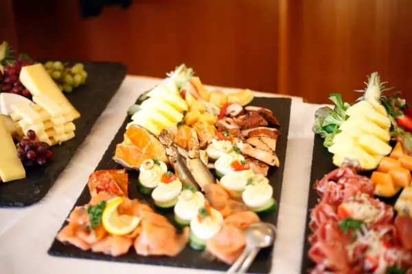 Ein Buffet mit vielfältigen Speisen wird kunstvoll angerichtet, um Gäste während einer Feier zu bewirten.