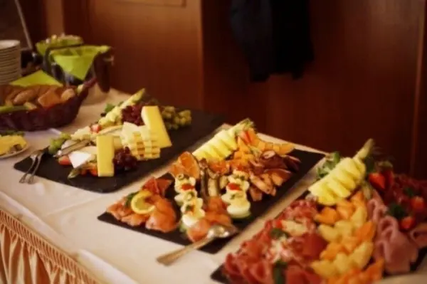 Platten mit köstlichem Buffet, die appetitlich angerichtet sind, stehen auf einem Tisch in einem festlichen Raum.