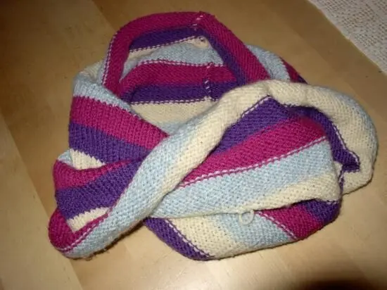 Ein bunten, gestrickter Schlauch liegt ordentlich auf einem Tisch, bereit für das Rundstricken für Anfänger.