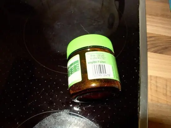 Ein Glas mit getrockneten Kräutern steht auf einer Kochplatte in einer modernen Küche, bereit zur Lagerung.