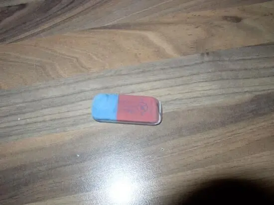 Ein Radiergummi liegt auf einem Tisch, bereit zum Reinigen, auf der Holzoberfläche sichtbar und unbenutzt.