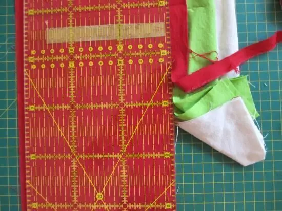Auf einem Schneidebrett liegt ein roter Rollschneider, der Papier präzise schneidet, um es für ein Projekt vorzubereiten.
