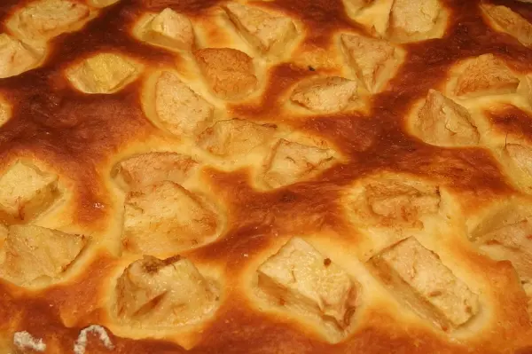 Ein goldbrauner, nicht gegangener Hefeteig für Blechkuchen, der frisch aus dem Ofen kommt und gleich serviert wird.