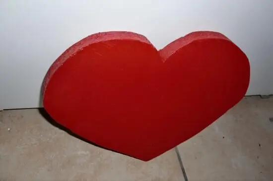 Ein rotes Herz aus Pappe liegt auf dem Boden, bereit für ein preiswertes Geschenk zum Valentinstag.