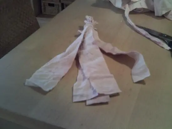 Ein selbstgemachtes Hundespielzeug aus zerrissenen Stoffstreifen liegt auf einem Tisch, bereit zum Spielen.