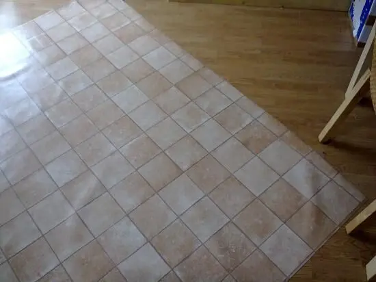 Ein großer Stoff liegt auf einem Holzboden, perfekt vorbereitet zum Zuschneiden beim Nähen.