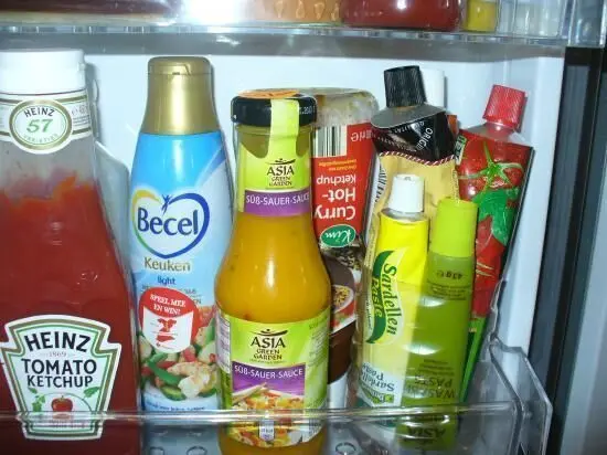 Flaschen und Tuben sind im Kühlschrank ordentlich eingeordnet, zusammen mit verschiedenen Lebensmitteln in einem frischen Umfeld.