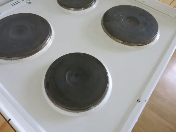 Schwarze Herdplatten auf einer weißen Kochplatte, die sauber und gepflegt aussehen, bereit zum Kochen in einer modernen Küche.