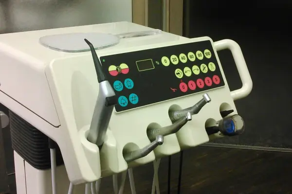Ein Zahnarztgerät mit bunten Tasten und Schläuchen steht in einer Praxis, bereit für eine Lachgas Behandlung bei Angstpatienten.