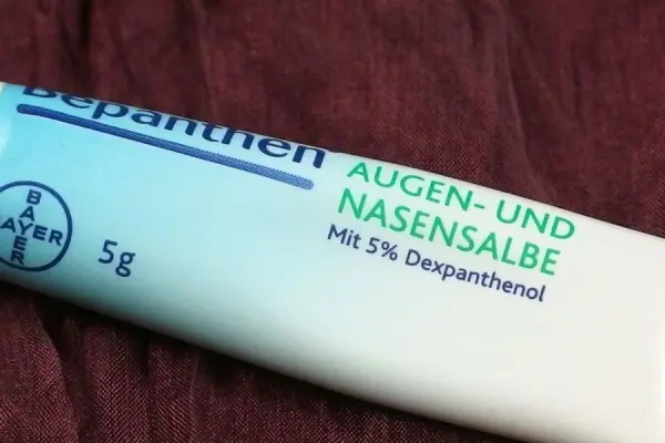 Eine Tube Bepanthen Augen- und Nasensalbe mit 5% Dexpanthenol liegt auf einem braunen Stoff. Text: "BAYER, 5g".