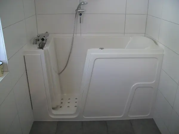 Eine barrierefreie Badewanne steht in einem modernen Badezimmer, bereit für das Einsteigen und Entspannen.