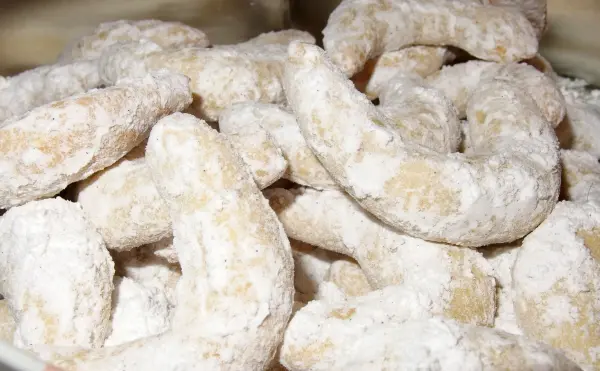Leckere Vanillekipferl liegen in einer Schüssel, mit Puderzucker bestäubt, bereit zum Genießen.