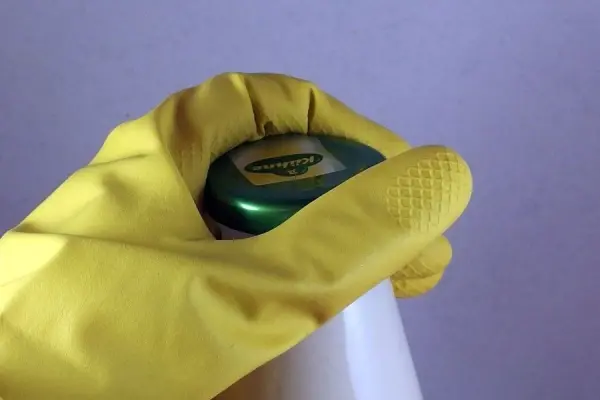 Eine Hand mit Gummihandschuh öffnet einen Flaschenverschluss, um Lebensmittel mit Konservengläsern leicht zugänglich zu machen.