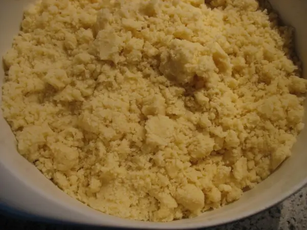 Eine Schüssel mit krümeliger Streuselmasse, bereit zum Backen für die Zwetschgen-Streusel-Torte in einer Küchenumgebung.