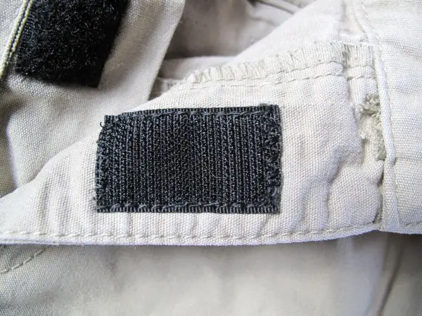 Ein Klettband ist an einer Kinderhose anstelle des kaputten Reißverschlusses angenäht, um sie funktionsfähig zu machen.