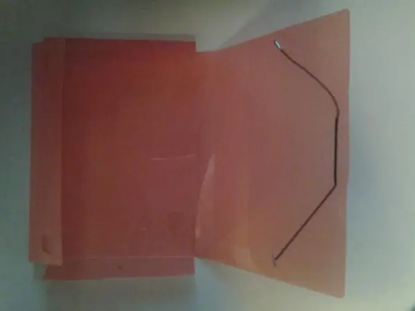 Ein transparenter Faltordner liegt offen auf einer Fläche, um Hemd oder Bluse ordentlich zu verstauen.