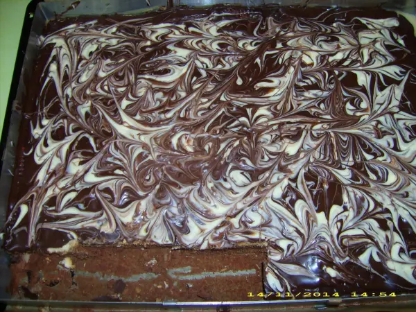 Ein schokoladiger Karamellkuchen mit swirled Musterung steht in einer Backform auf einer Arbeitsfläche, bereit zum Servieren.