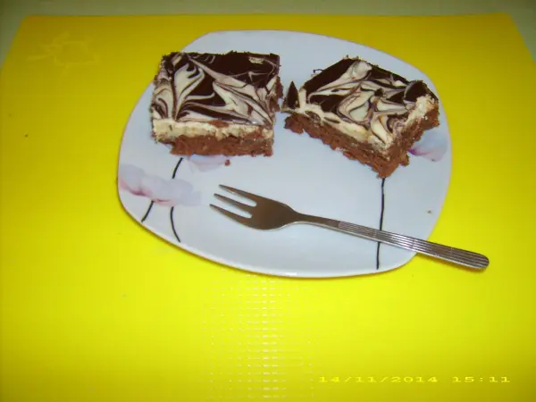 Ein Schoko-Karamell-Kuchen liegt auf einem Teller, zwei Stücke sind herausgeschnitten, umgeben von einem gelben Hintergrund.