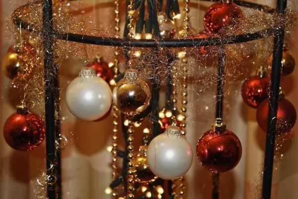 Ein dekorativer Weihnachtsbaumersatz schmückt sich mit glänzenden Kugeln und Lichtern in festlicher Umgebung.