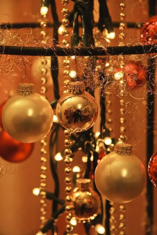 Ein dekorativer Weihnachtsbaumersatz hängt mit funkelnden Lichtern und glänzenden Kugeln, die eine festliche Stimmung schaffen.