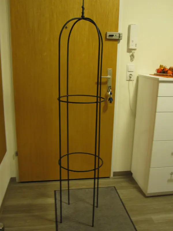 Ein schwarzer Metallrahmen steht auf einem Boden in einem Raum, bereit, als moderne Weihnachtsbaum-Alternative dekoriert zu werden.