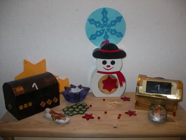 Bunte Adventskalender stehen auf einem Tisch, sanfte Weihnachtsdekoration, um die Vorfreude auf Weihnachten zu fördern.