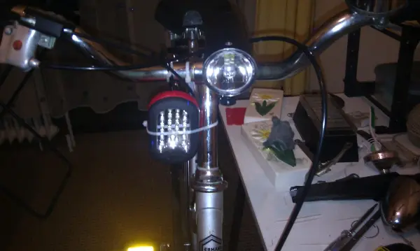 Ein Fahrrad mit rostfreien Metallteilen steht auf einem Tisch, umgeben von Werkzeugen und Pflanzen.