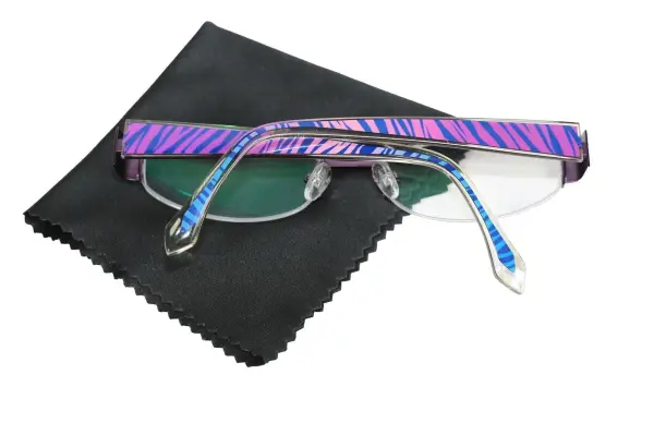Eine Brille mit bunten Bügeln liegt auf einem schwarzen Reinigungstuch, bereit für den Austausch der Bügel.