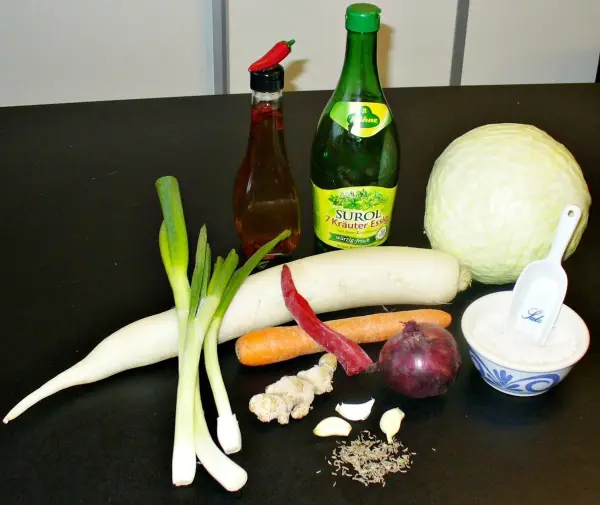 Weißkohl, zusammen mit frischen Zutaten wie Lauch, Karotte und Gewürzen, bereit zur Zubereitung von Kimchi.