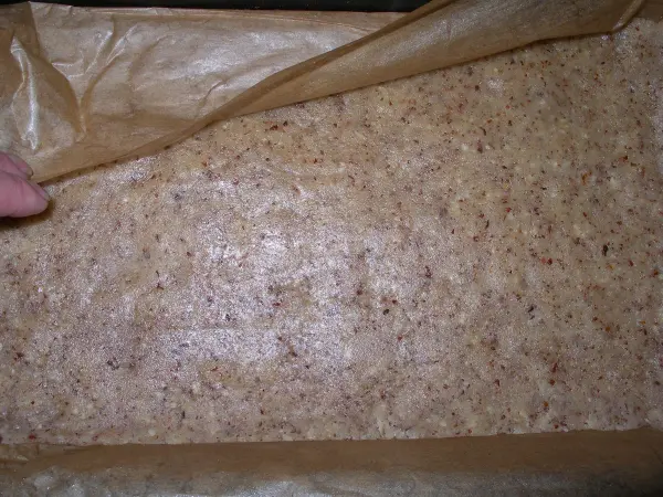 Eine handgefertigte Bodenbasis für den Schoko-Karamell-Kuchen wird vorsichtig aus der Form gehoben, um die Venusschnitten zuzubereiten.