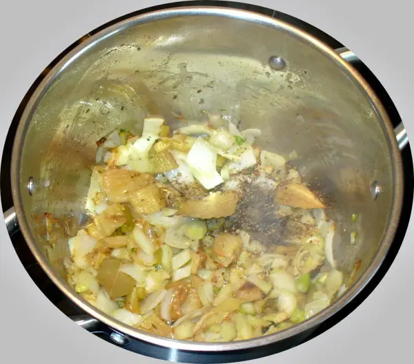 Ein Topf mit angebratenem Gemüse dampft in der Küche und bereitet einen schwedischen Fischtopf zu.