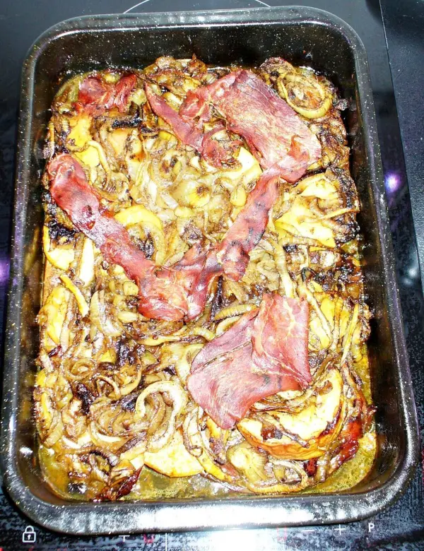 Zarte Leber liegt in einer Auflaufform, umgeben von karamellisierten Zwiebeln, im Backofen gebraten.