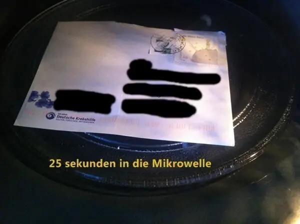 Ein Briefumschlag liegt in der Mikrowelle und wird zum Ablösen von Briefmarken für 25 Sekunden erhitzt.
